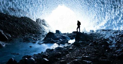 Representational image of a man walking through a cavern of ice (Cover Image Source: Pexels | Julien Riedel)