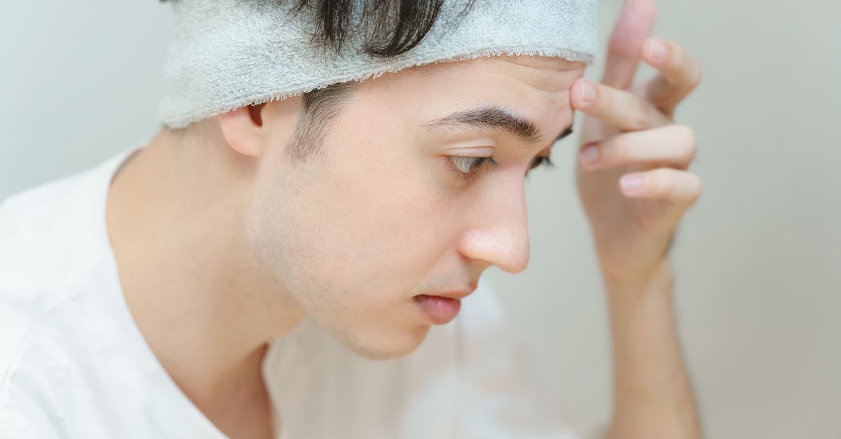 A person wearing all white washes their face.