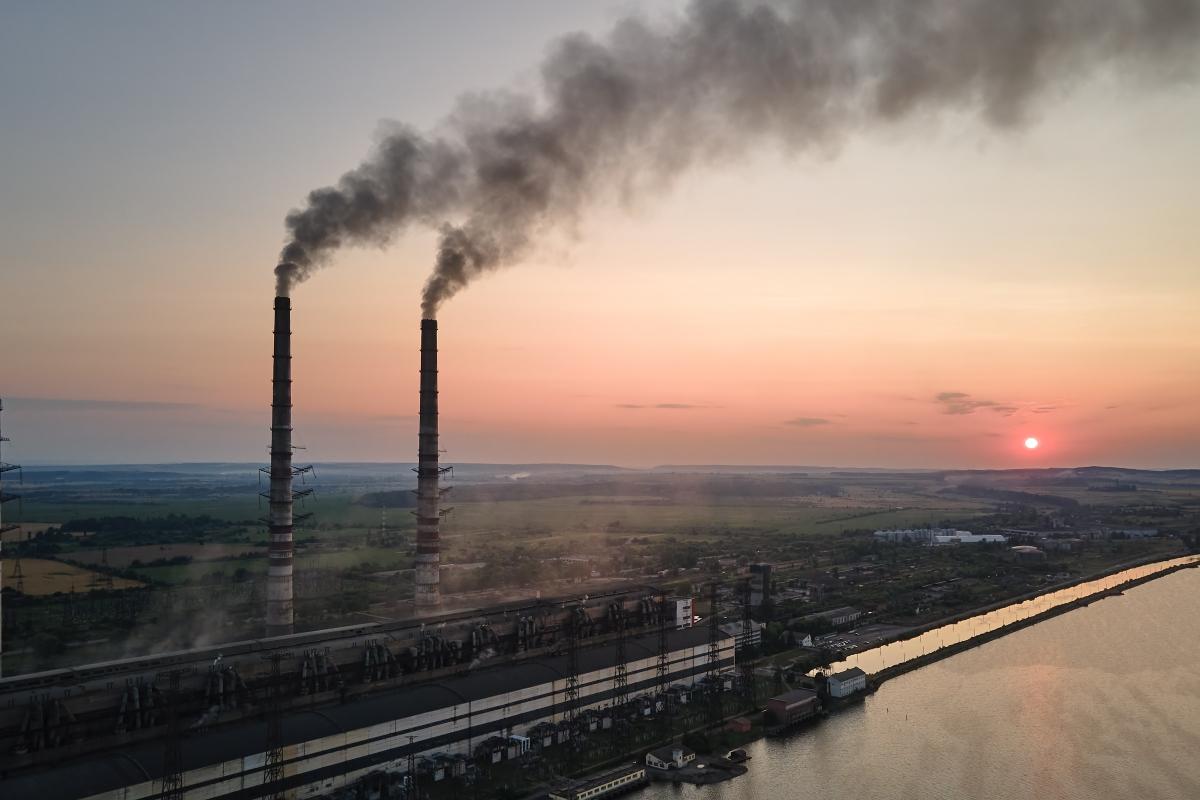 Smokestacks polluting the air at sunrise.