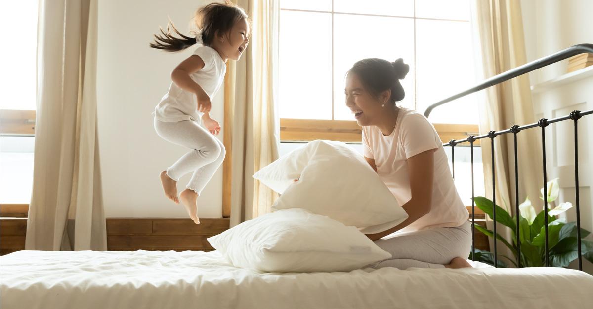 Mom and daughter play on bed