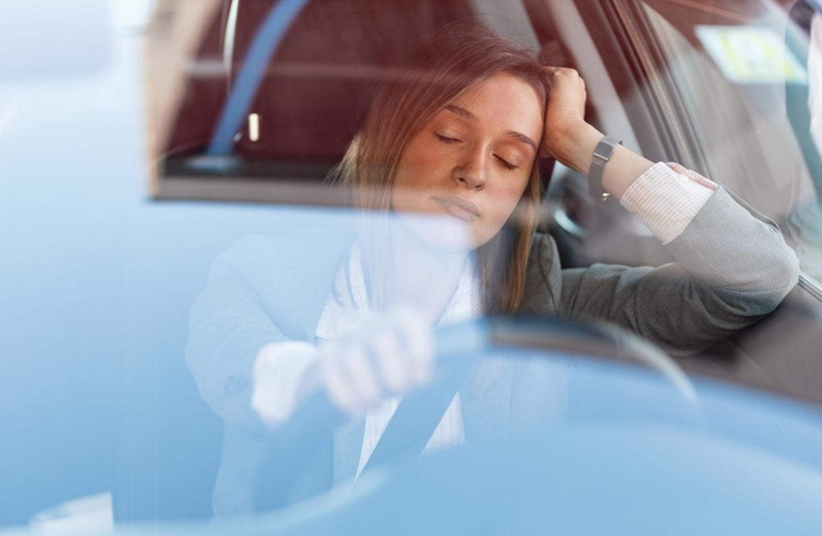 Woman resting eyes while behind the wheel