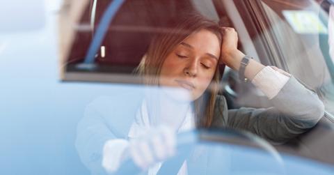 Woman resting eyes while behind the wheel