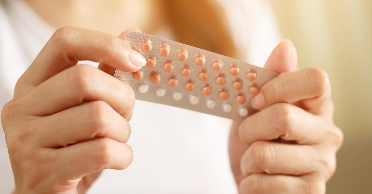 Woman holding birth control pills in her hands. 