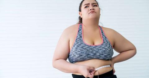 An overweight woman measures her waist size with a tape and feels stressed by her weight gain. (Representative Cover Image Source: Getty Images | Sukanya Sithhikongsa)