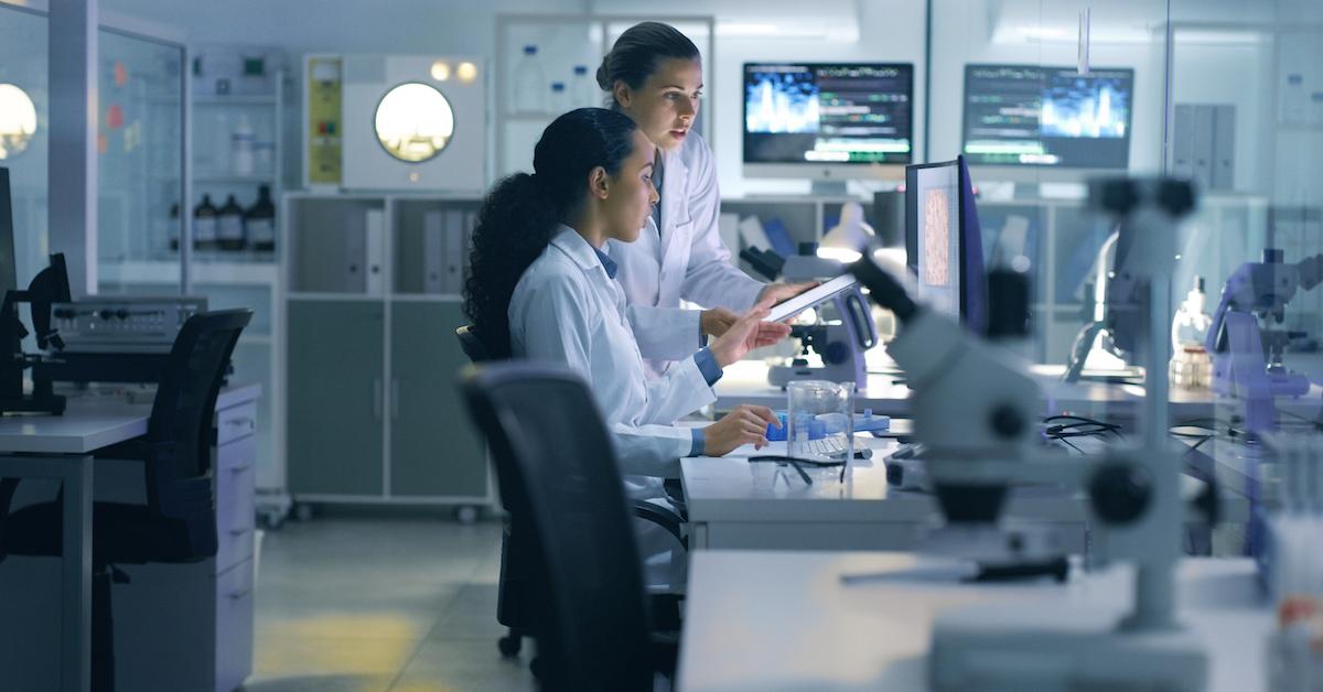 Two women in lab coats work in a lab