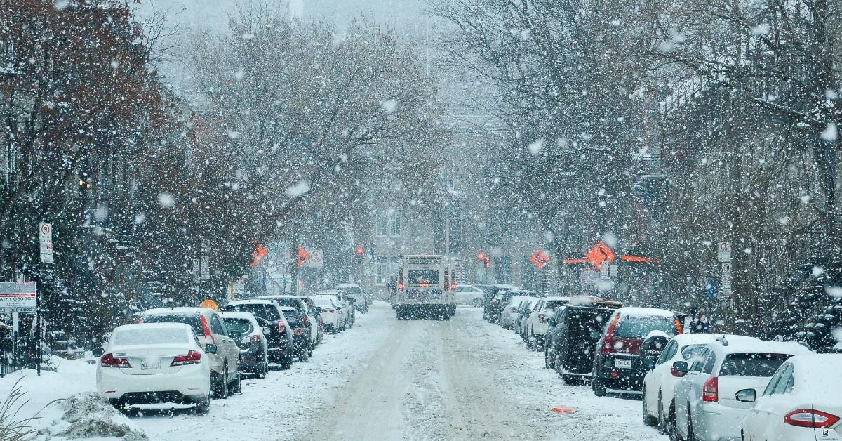 Cars are parked along a snowy city street