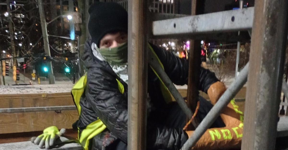 A local Stop Cop City activist uses a reinforced pipe to lock themselves to construction equipment.