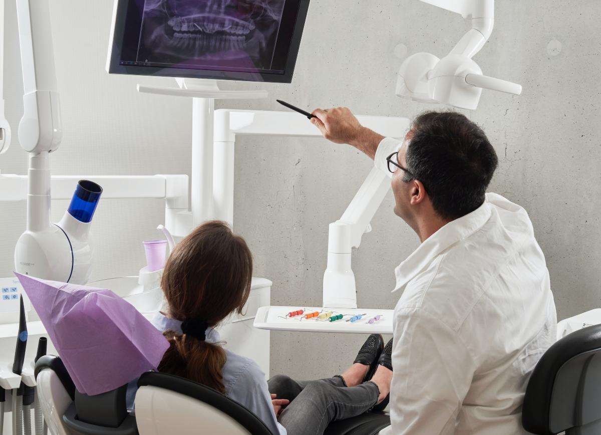 male dentist discussing dental care with a patient