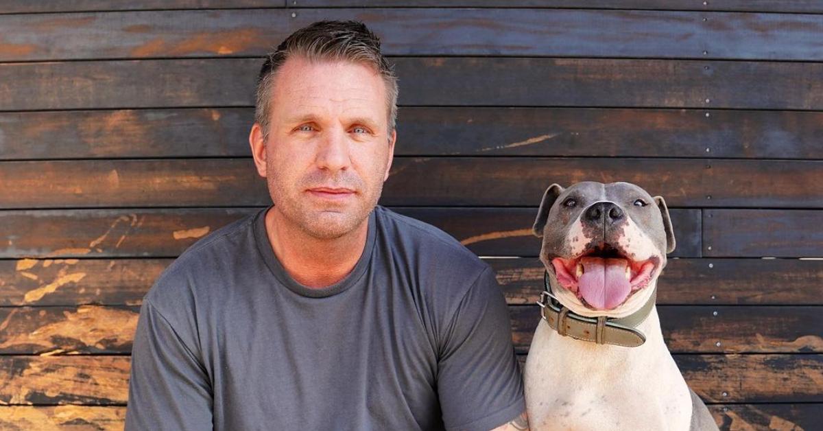 Photo of entrepreneur and Genius Litter founder Ramon Van Meer beside a dog in front of a wood slat wall