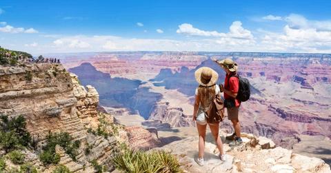 A couple on top of the mountain looking at the beautiful landscape of the South Rim of Grand Canyon National Park. (Representative Cover Image Source: Getty Images | MargaretW)