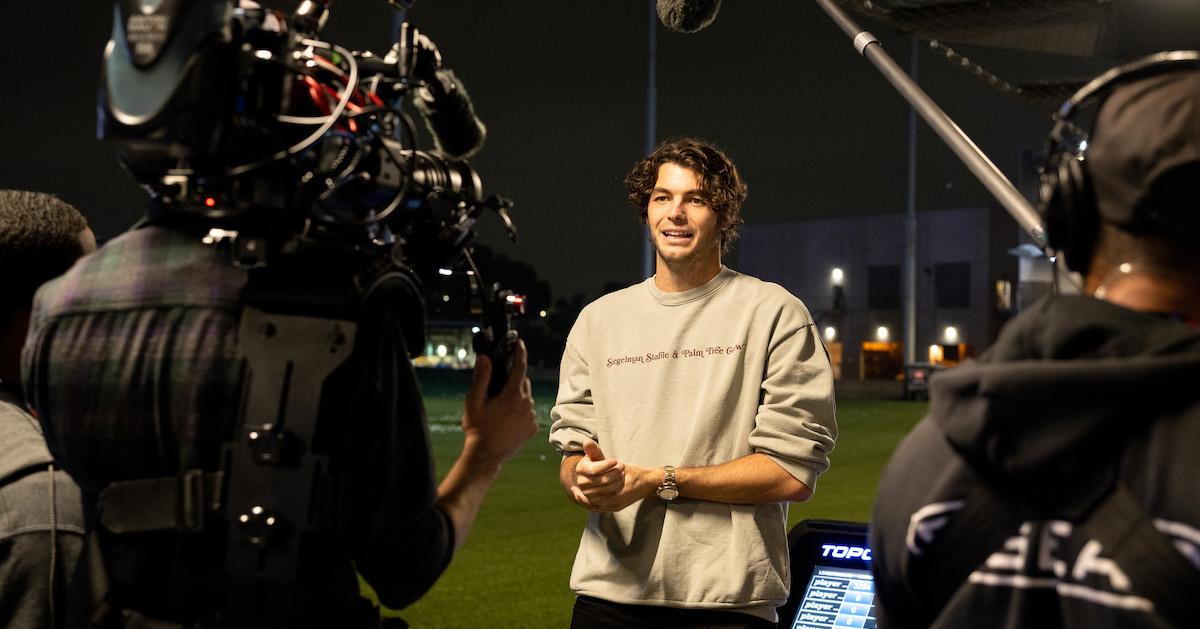 Taylor Fritz stands on a golf course and speaks into a video camera.