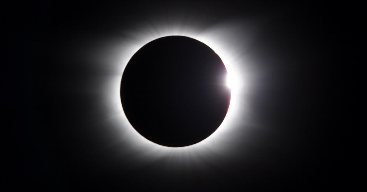 A solar eclipse where the moon is covering the sun and the sky is dark. 