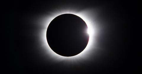 A solar eclipse where the moon is covering the sun and the sky is dark.