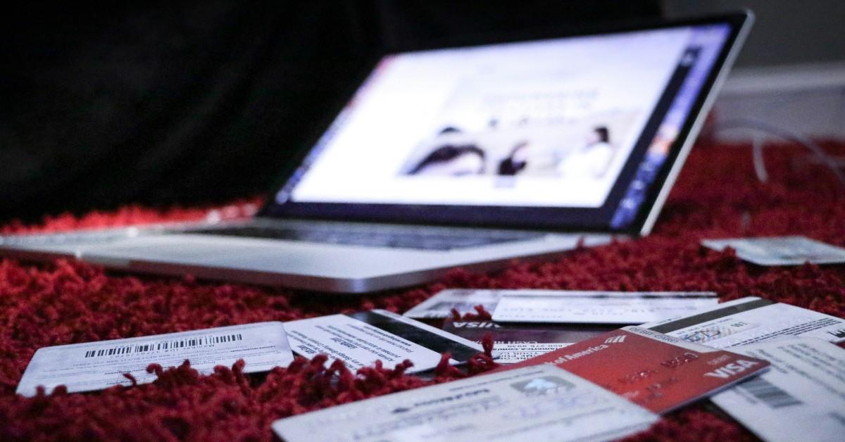 A laptop sits open in the background while surrounded by credit cards