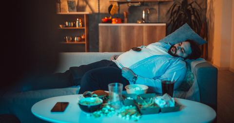 Photo of man on couch sleeping in front of television