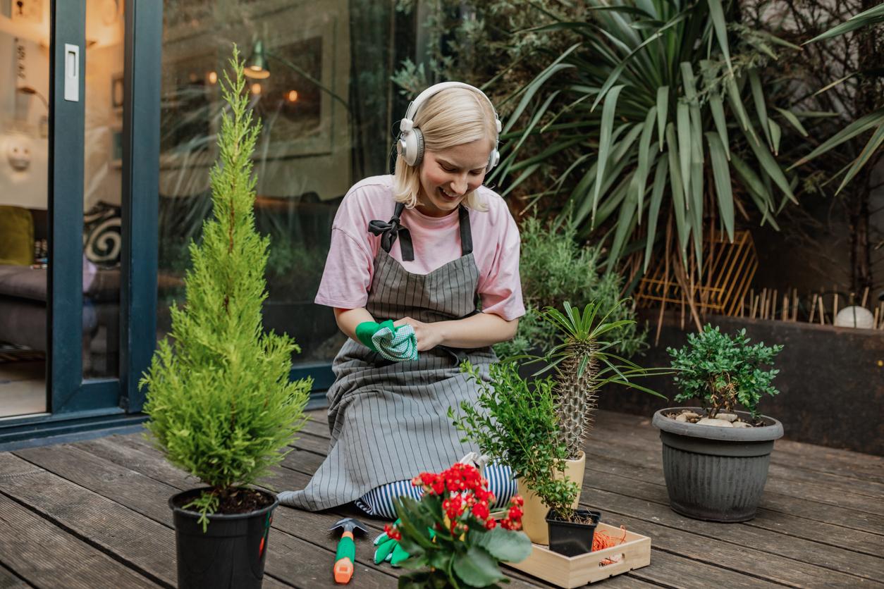 Person wearing headphones while gardening outside on porch