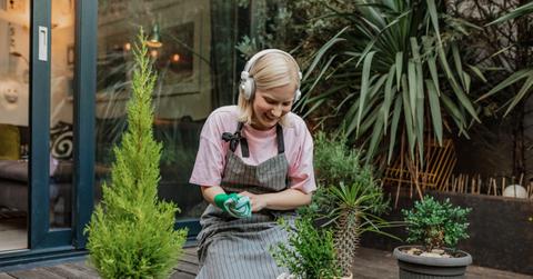 Person wearing headphones while gardening outside on porch