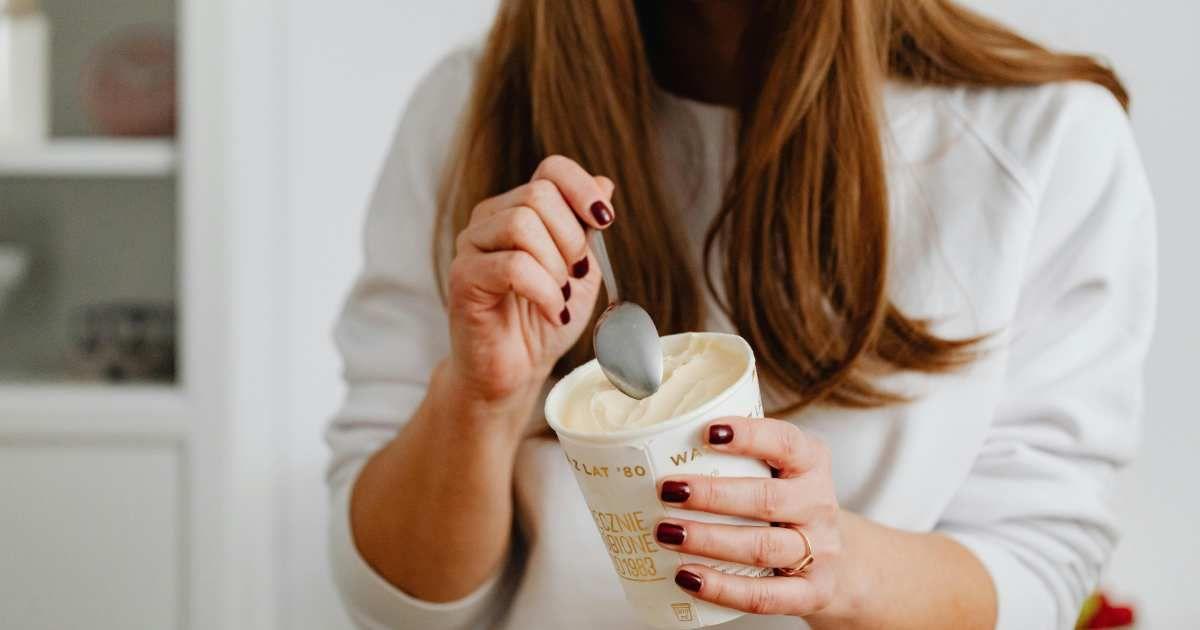 A woman eating a dollop of ice cream from a tub (Representative Cover Image Source: Pexels | Kaboompics.com)