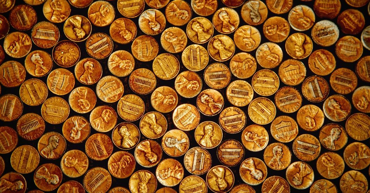 A collection of U.S. pennies sit on a black platform
