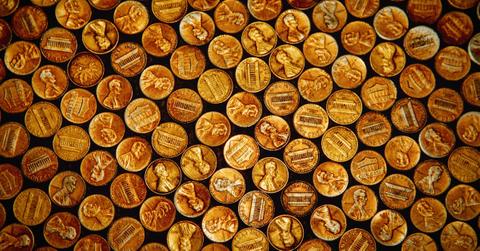 A collection of U.S. pennies sit on a black platform