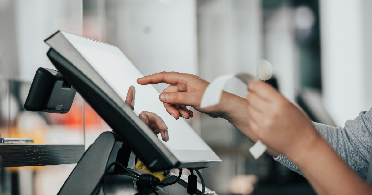 A person keys info into a cash register touch screen