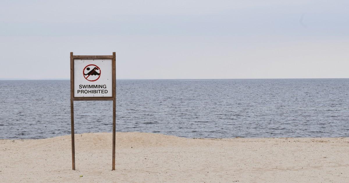 A sign alerts visitors at the beach the swimming is prohibited 