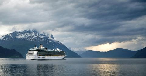 A cruise ship sails past a snow capped mountain