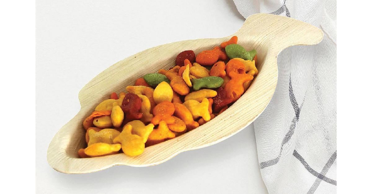 Fish-shaped palm leaf eco-friendly disposable tray holding goldfish crackers.