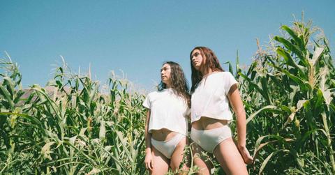 Two models wear white KENT underwear and T-shirts in a field