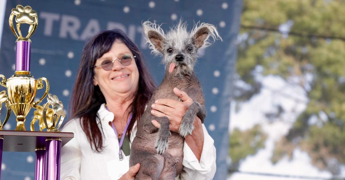 Scooter and his human with his trophy for World's Ugliest Dog.