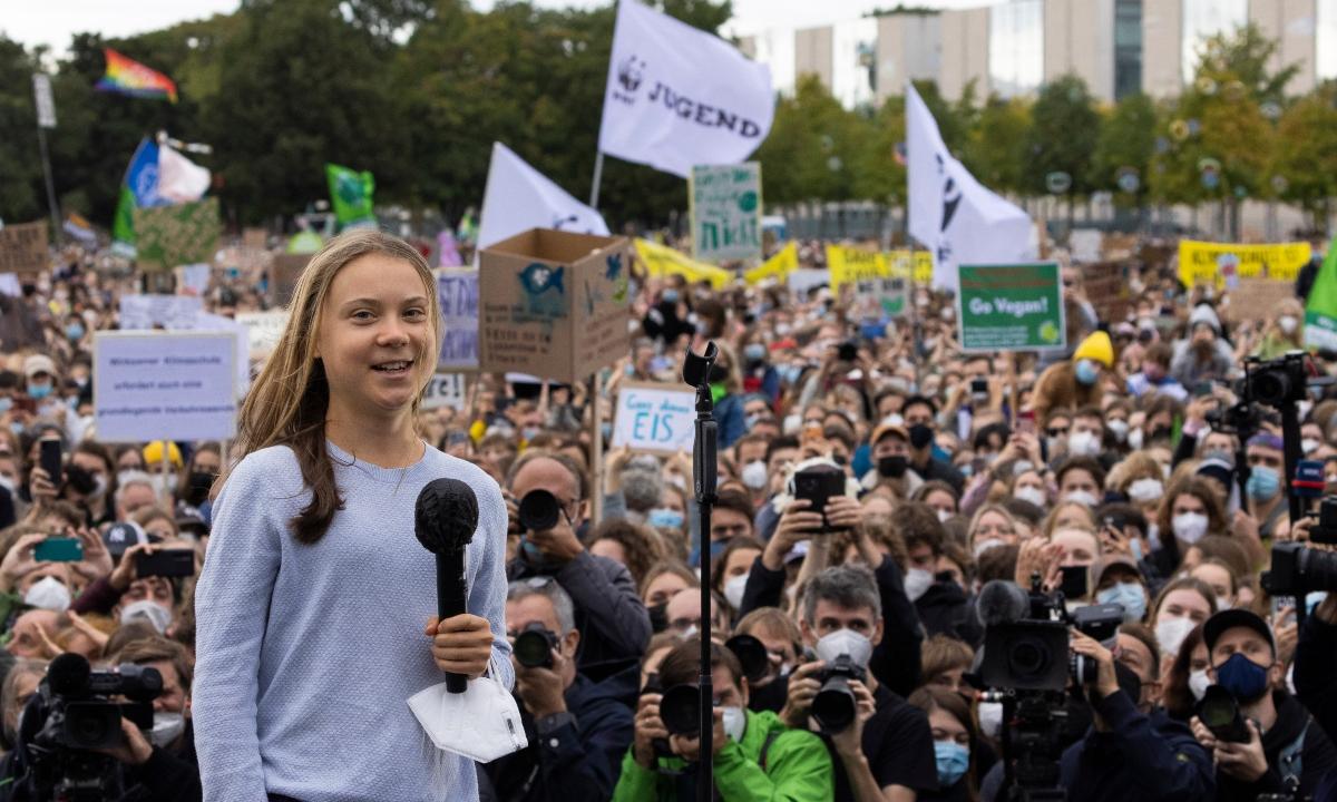 Greta Thunberg speaking to a crowd of people. 