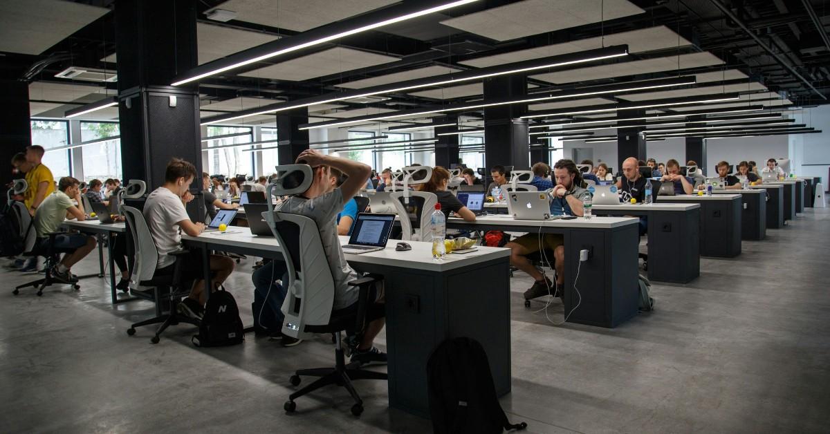 People sit in an open concept office, working at their desks