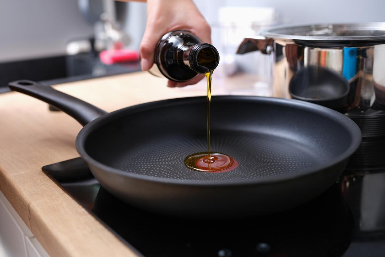 A chef pours olive oil into a pan coated with Teflon.