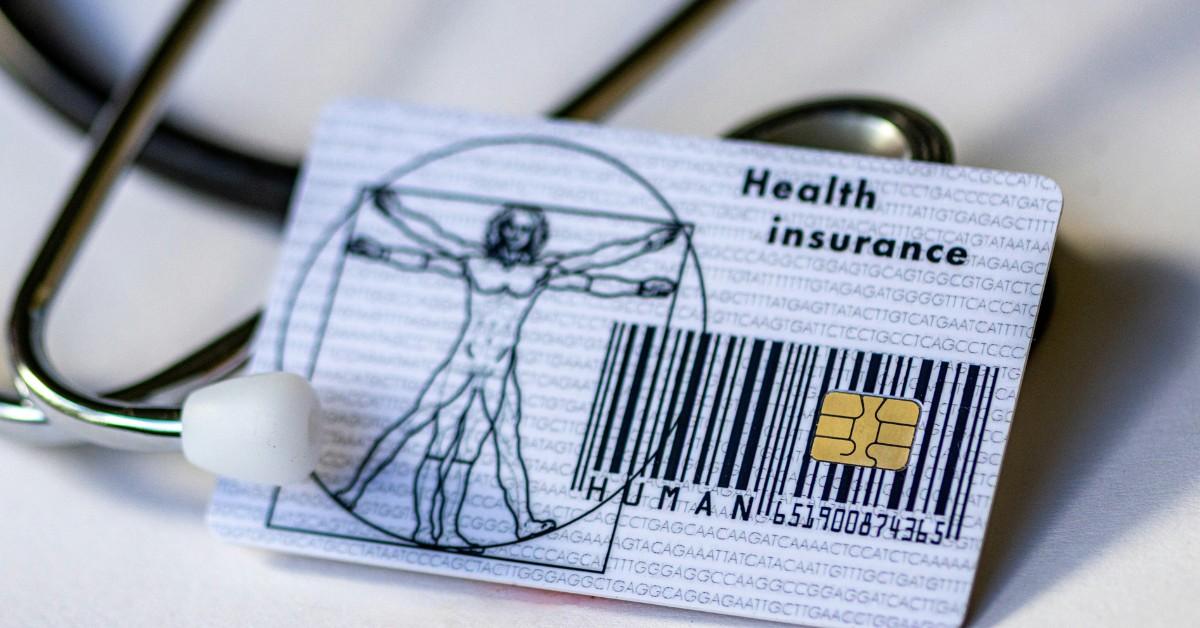 An insurance card sits next to a stethoscope 