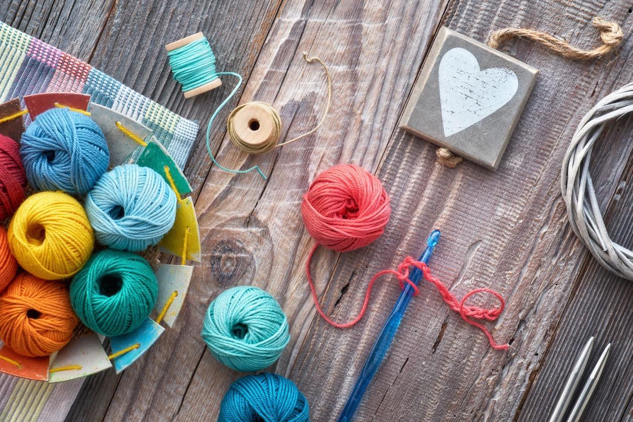 Various colored yarns and crochet supplies scattered on a table.