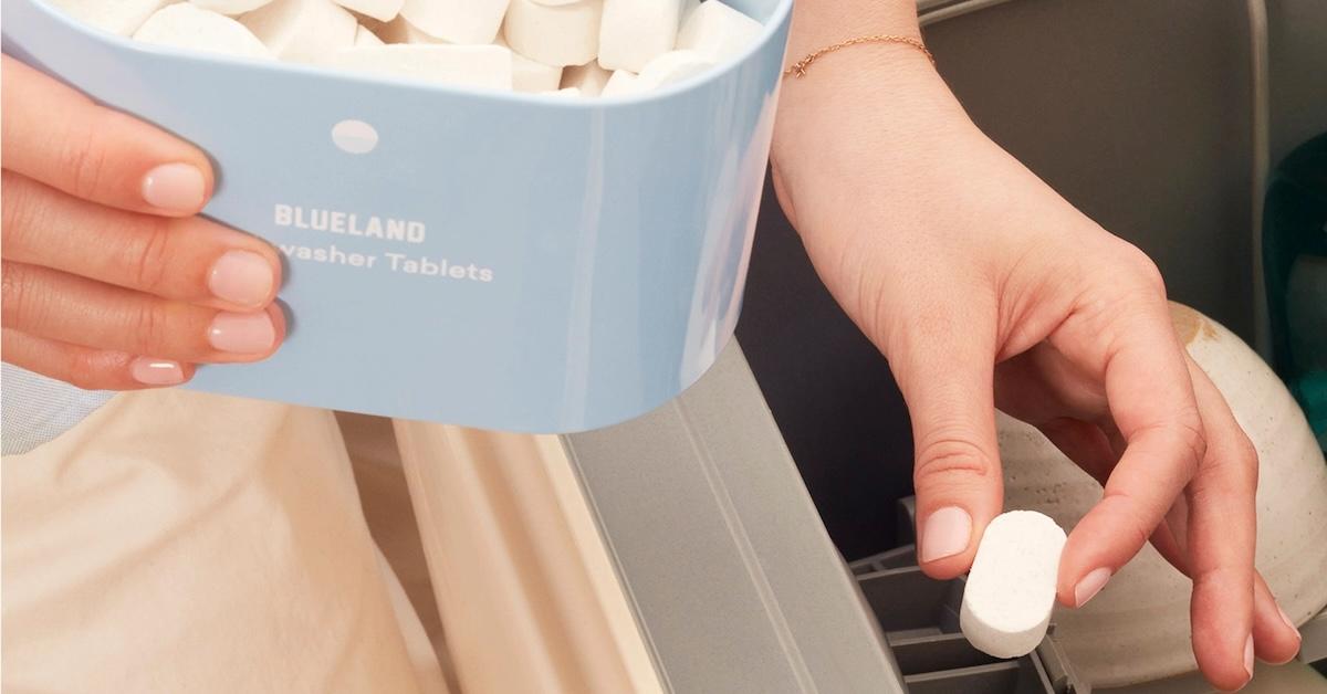 Eco-friendly dishwasher detergent tablets being placed into a dishwasher.