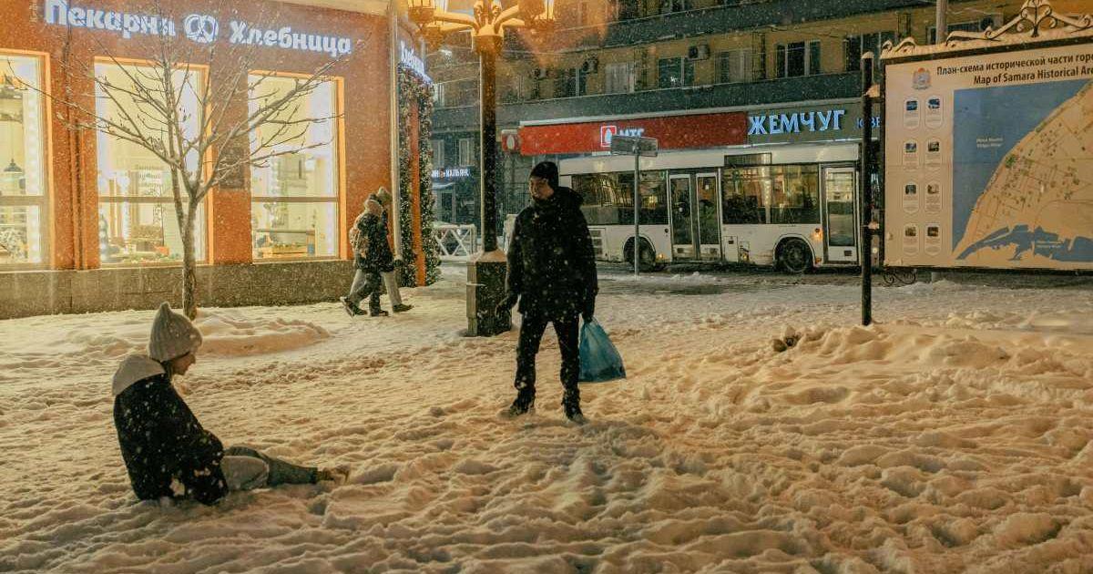 People chilling in a snowy evening in a city. (Image Source: Pexels | Daniil Kondrashin)