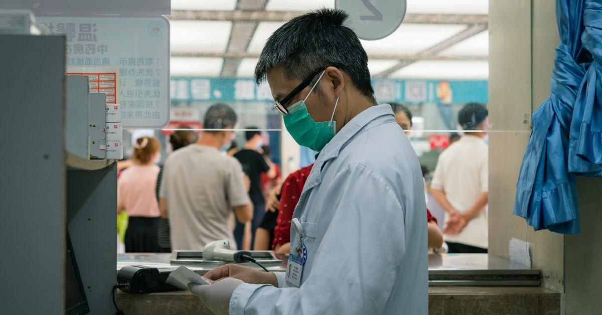 A man wears a face mask while working in a medical setting