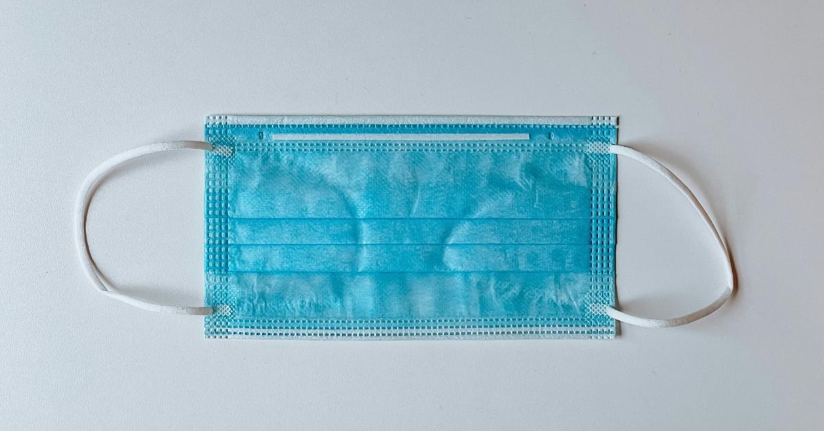 A blue face mask sits on the counter