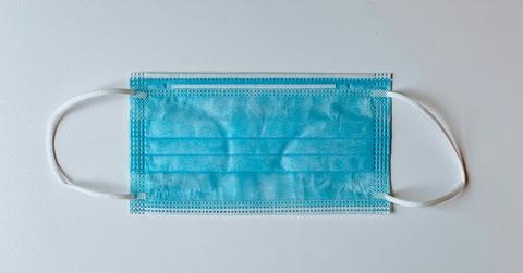 A blue face mask sits on the counter