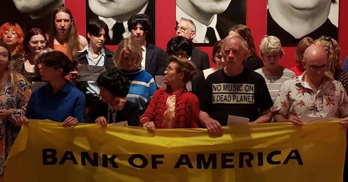 Fossil Free London activists at the National Portrait Gallery holding a yellow banner.