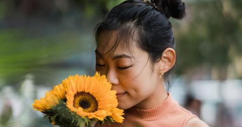 A girl smelling sunflowers. (Representative Cover Image Source: Pexels | Greta Hoffman)