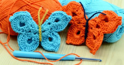 Two crochet butterflies, one orange and one blue.