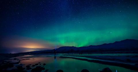 The northern lights are visible across the night sky