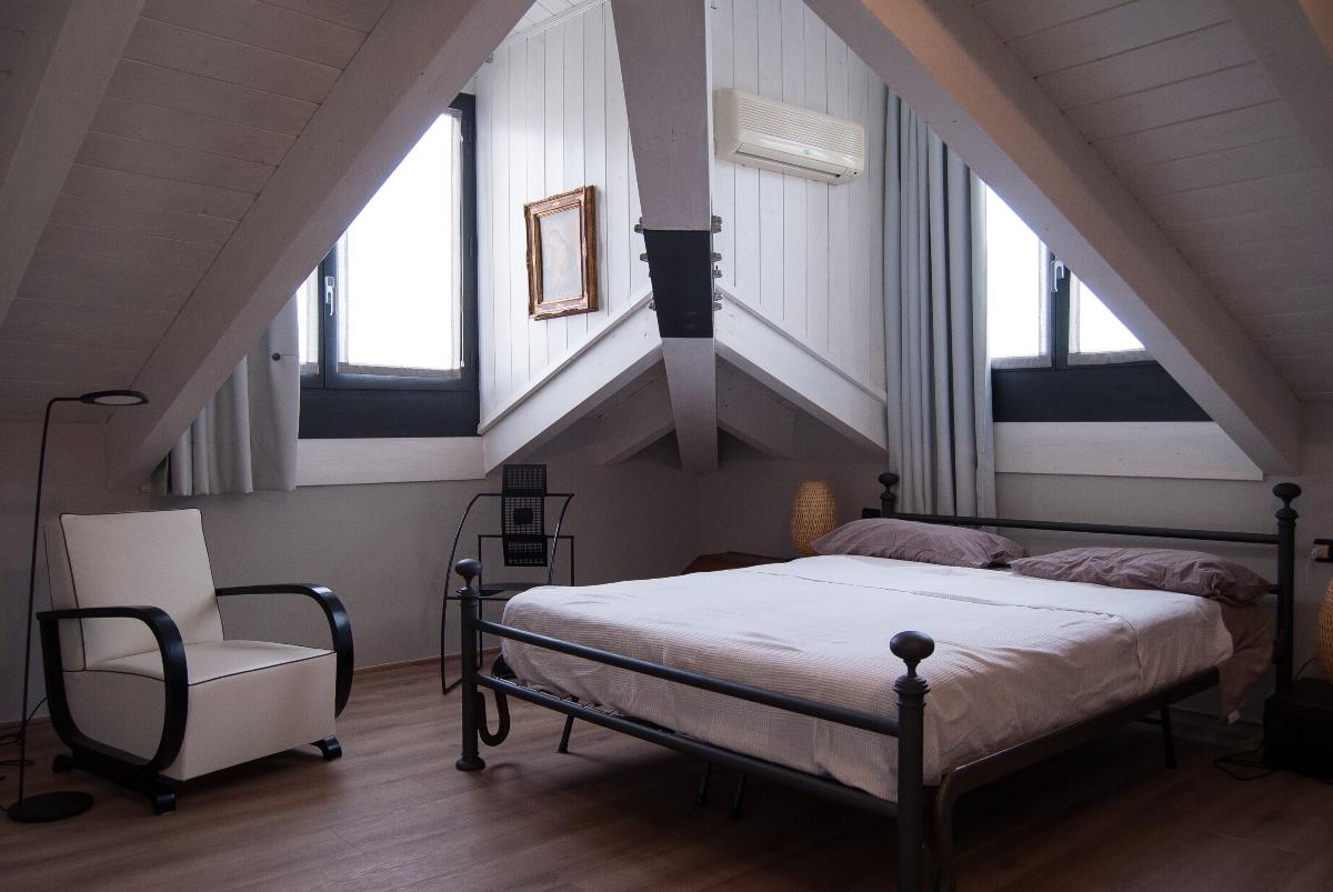 bed in a room with slanted roofs