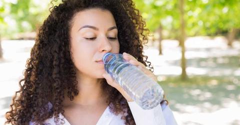 A young woman drinks packaged drinking water. (Representative Cover Image Source: FreePik | Katemangostar)