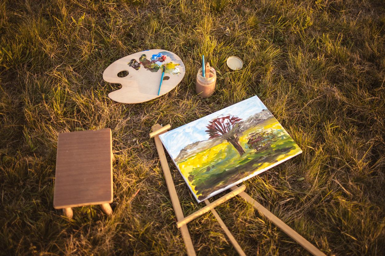 Canvas, easel, and painting supplies on the grass