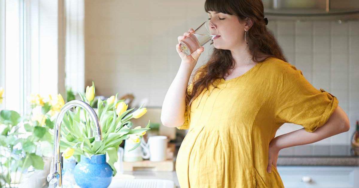 Pregnant woman drinking a glass of water in the kitchen at home (Representative Cover Image Source: Getty Images | Doughal Waters)