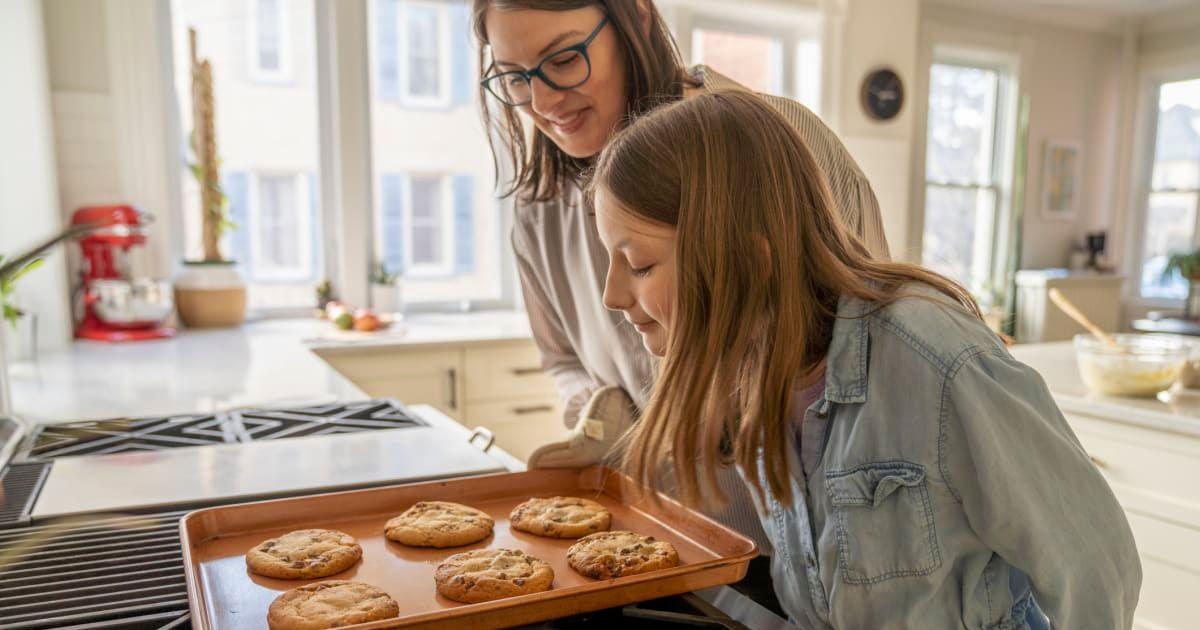 Mother and daughter baking chocolate-chip cookies in the kitchen (Representative Cover Image Source: Getty Images | FatCamera)