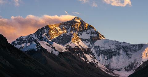 A snow covered Mount Everest appears in the distance